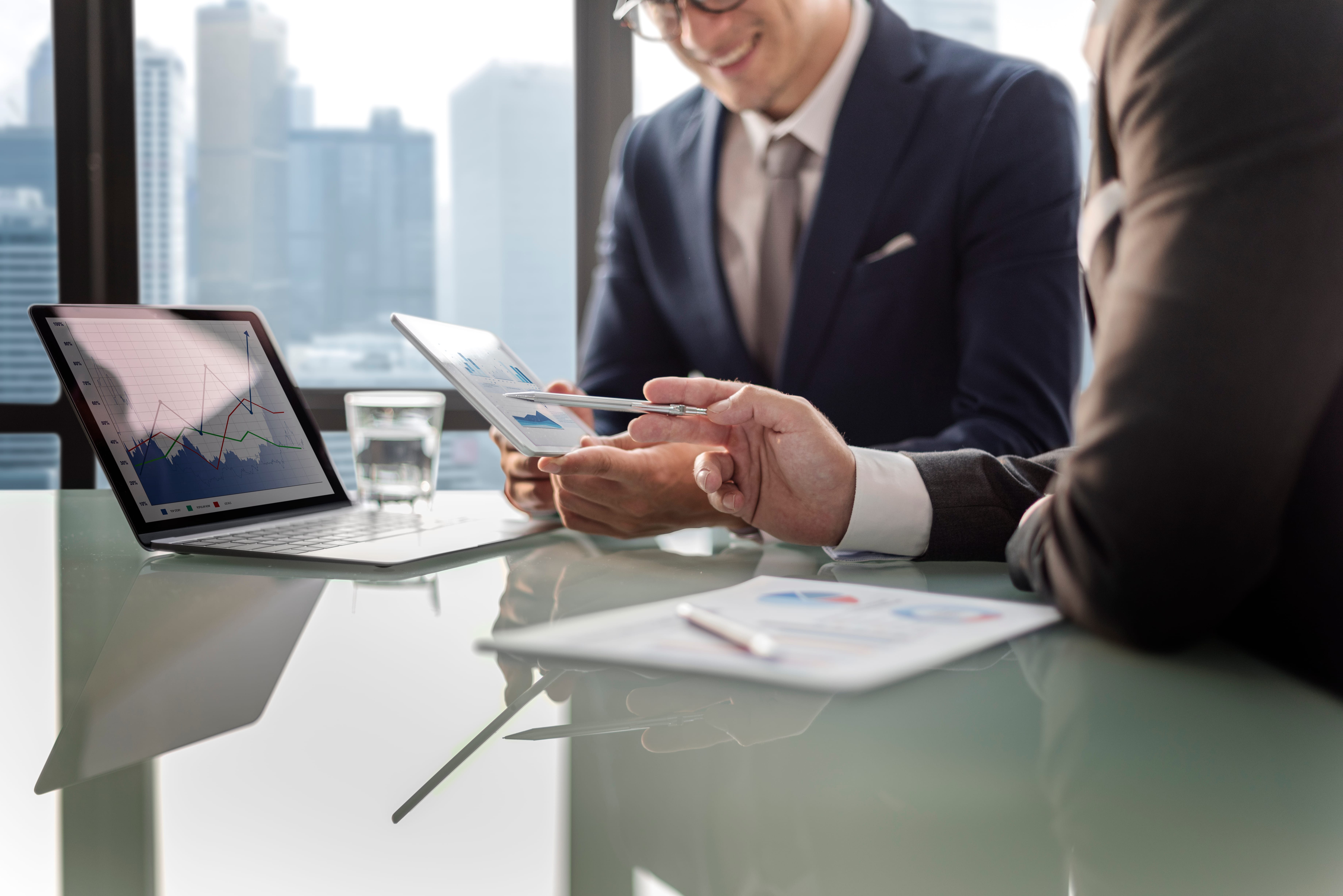 Financial consultants reviewing nonprofit budget data and fiscal reports on laptop